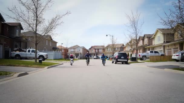 Tři mladí chlapci jezdí na kolech po ulici ve zpomaleném filmu