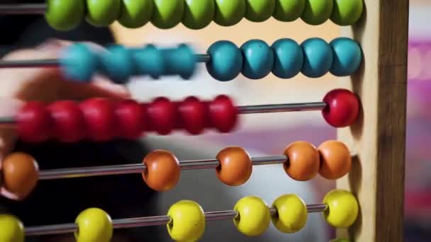 Young boy playing with a colourful abacus in slow motion