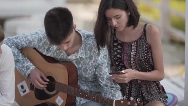 Tinédzser Fiú Gitárral Lány Okostelefonnal Beszélgetés Melyik Dalt Fogják Játszani — Stock videók