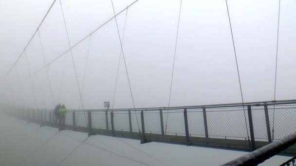 霧の中でヨーロッパで最も高い吊り橋を渡って歩く 吊り橋は悪いガステインのStubnerkogelにあります — ストック動画