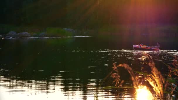 Långskott Pappa Med Dotter Njuter Gummibåt Rida Färgglada Solnedgången — Stockvideo