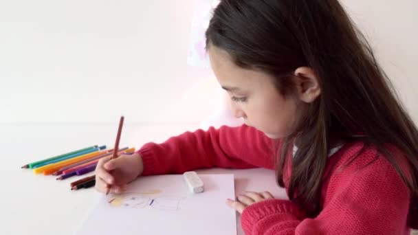 一个年轻姑娘坐在一张明亮的桌子旁 桌上的颜色是棕色的铅笔 — 图库视频影像
