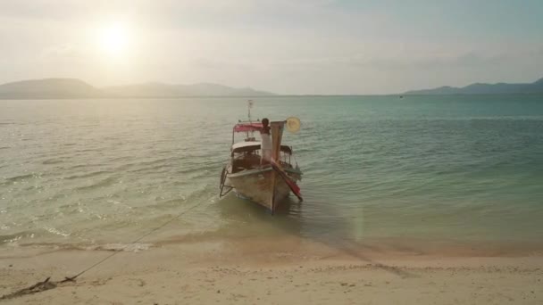 背景に夕日と空気中で手を上げる長い尾のボートの上のビーチドレスの女の子 — ストック動画