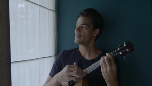 Jeune Homme Heureux Jouant Ukelele Devant Fenêtre Lumière Douce — Video