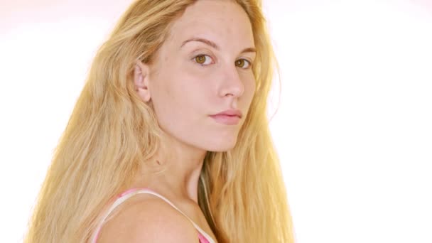 Beyaz Bir Arka Planda Genç Sarışın Bir Kadın Omzunun Üstünden — Stok video