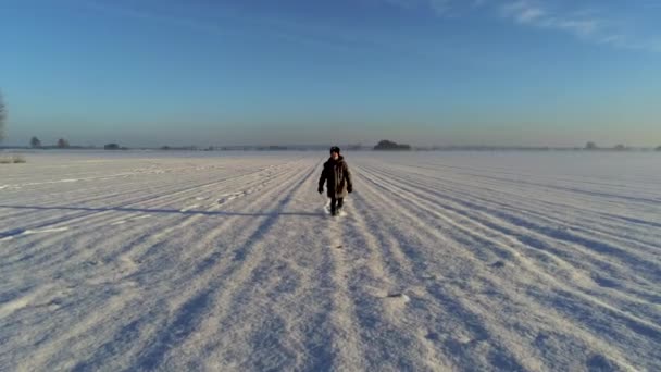 小さな男の子のフィールドに雪に満ちて歩くのドリーショット — ストック動画