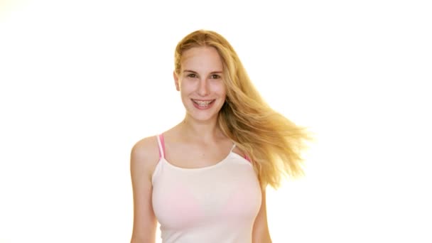風機械は女性の長いブロンド髪を吹く彼女のポーズとクスクスとしてA平らな白いスタジオの背景 — ストック動画