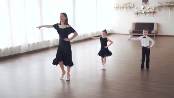 Szakmai salsa táncos tanít duó gyerekek koreográfia egy stúdióban, széles lövés