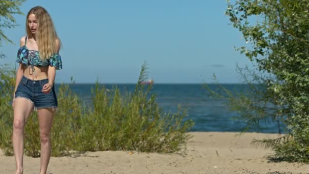 Повільний Постріл Блондинки Дівчина Йде Пляжу Морем Задньому Плані Вони — стокове відео