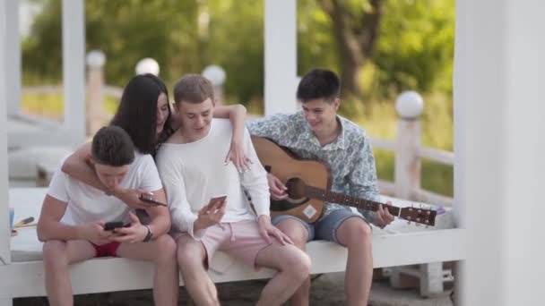 Grupp Glada Tonåringar Njuter Deras Sommarlov City Beach Med Gitarr — Stockvideo