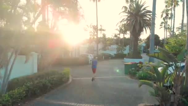 Aérial Adolescent Faisant Jogging Dans Rue Pendant Coucher Soleil — Video