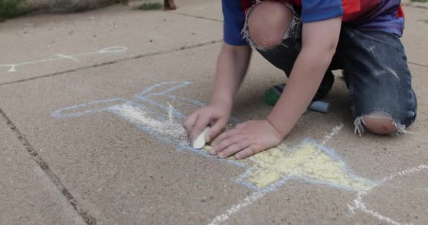 Ένα Νεαρό Χαρούμενο Αγόρι Σχεδιάζει Και Χρωματίζει Κιμωλία Στην Πλαϊνή — Αρχείο Βίντεο