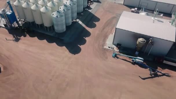 Drone aerial view of an agribusiness that exports cover seeds around the world located in Nebraska USA; the view includes grain storage bins, warehouses, and semi tractors for shipping
