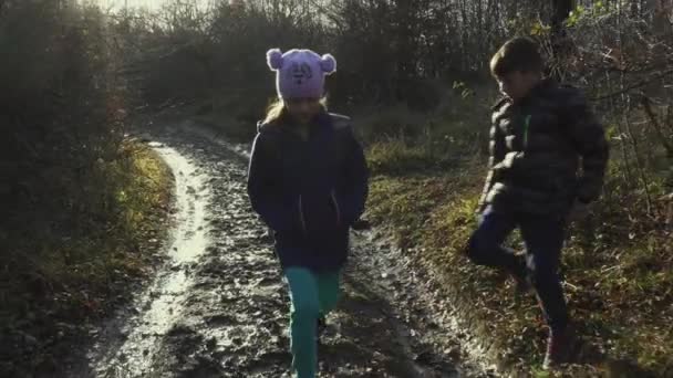 Tre Barn Går Längs Kall Lerig Bana Mot Kameran Bakgrundsbelysning — Stockvideo