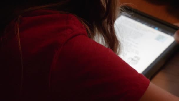 Dívka čtení její domácí úkol na inteligentní tablet