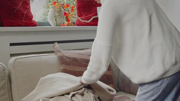Молодая Белая Женщина Идет Удобному Дивану Залезает Уютное Белое Одеяло — стоковое видео
