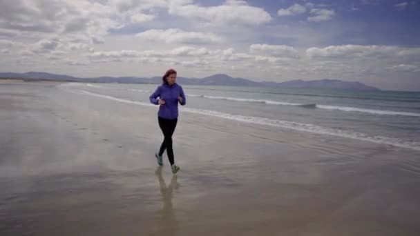 Tracking Dolly Shot Eines Mädchens Läuft Joggt Ufer Eines Sandstrandes — Stockvideo