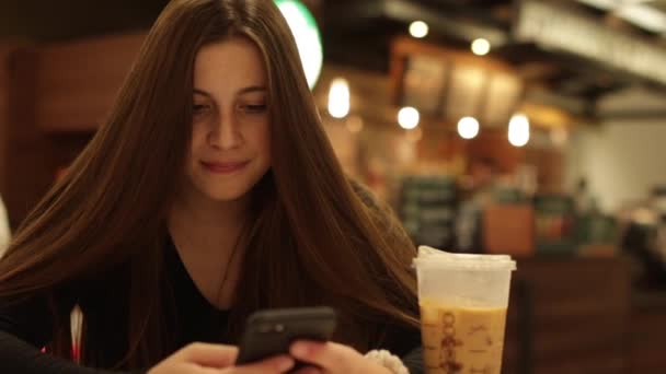 Dívka pomocí smartphone v kavárně, střední zblízka záběr