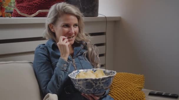 Dolly Young Caucasian Woman Watching Home While Eat Chips Laughing — Stok Video