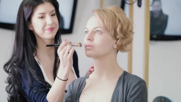 SLOW MOTION video tmavovlasý kosmetik použití make-up na krásné blond modelu