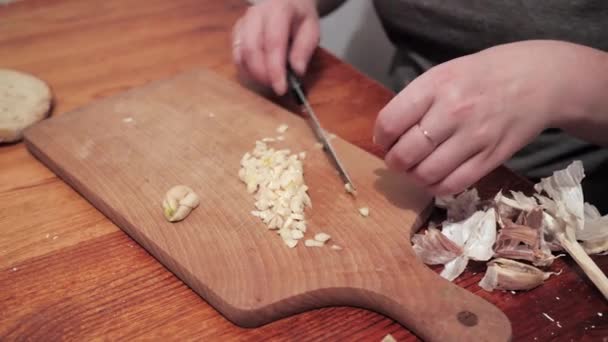 ナイフを持った女の手はまな板の上にニンニクを切る ニンニクでサンドイッチを作る準備 — ストック動画