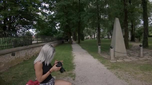 Zpomalení mladý krásný atraktivní blondýnka hledá fotky na kameře v parku, Kranj, Slovinsko