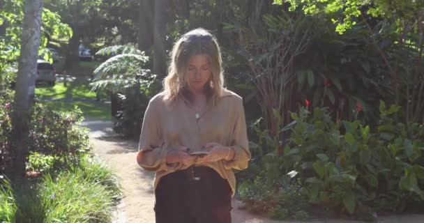 Молода Жінка Прогулюється Садом Своєму Мобільному Телефоні_Повільний Рух — стокове відео