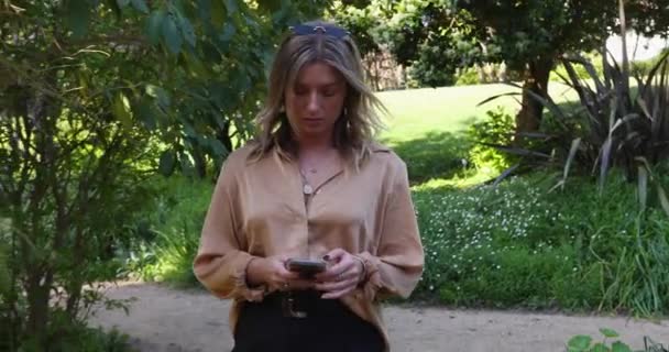Νεαρή Γυναίκα Περπατά Στον Κήπο Κινητό Της Τηλέφωνο Αργή Κίνηση — Αρχείο Βίντεο