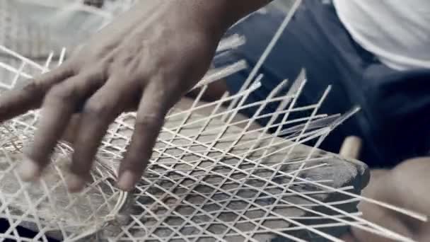 Muž plete bambusový rákos a vyrábí ručně vyrobený klobouk. Close up 4k záběry procesu výroby bambusové čepice