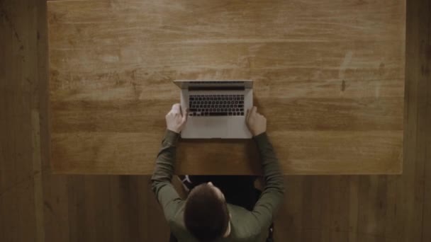 木製のテーブルの上で彼の仕事のために彼のラップトップコンピュータを使用して男 Top View Shot — ストック動画