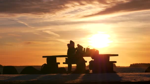 Silhouetten Von Familienpicknick Wintersonnenuntergang Mit Goldener Wolkenlandschaft Wasser — Stockvideo