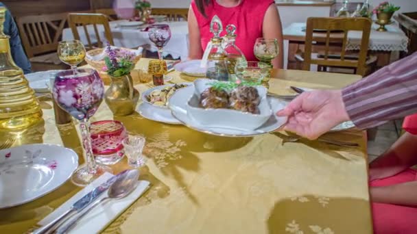 スロベニアの伝統的な願い事テーブルでメッツァリ料理を提供するウェイターの手のショットを閉じます — ストック動画