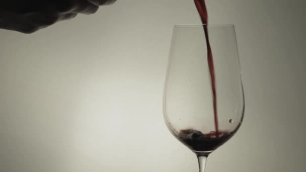 単一の茎のガラスに赤ワインを注ぐ手 閉じる — ストック動画