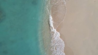 Kumsalı, turkuaz suyu ve Gili Meno Adası kıyılarını gösteren havadan yükselen tepe..