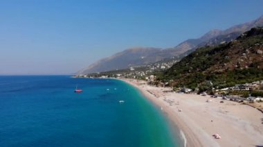 Arnavutluk 'un bozulmamış Dhermi plajı sakin kristal deniz suyuyla yıkanmış kum ve kayalarla dolu