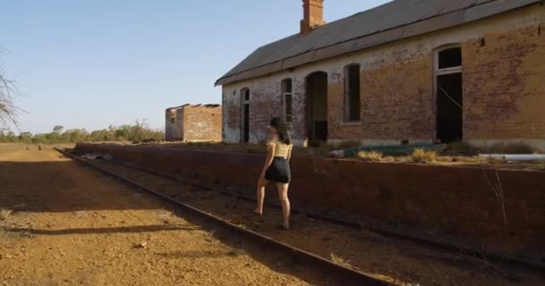 Terk Edilmiş Bir Kasabada Eski Bir Demiryolu Hattında Yürüyen Genç — Stok video