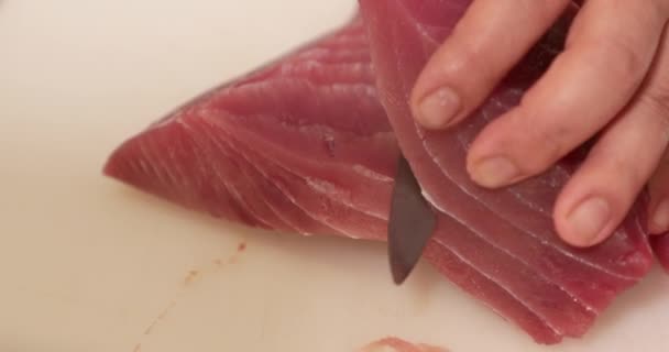 日本料理店で寿司を準備するために新鮮なマグロの魚の生肉をスライスするために使用されるシャープなナイフ 閉じる スローモーション — ストック動画