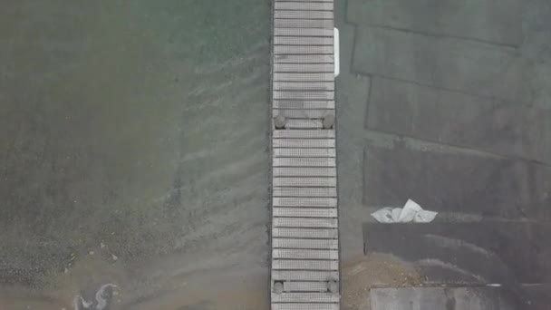 トルコ石の水の上に狭い木製の桟橋の空中オーバーヘッドショット — ストック動画