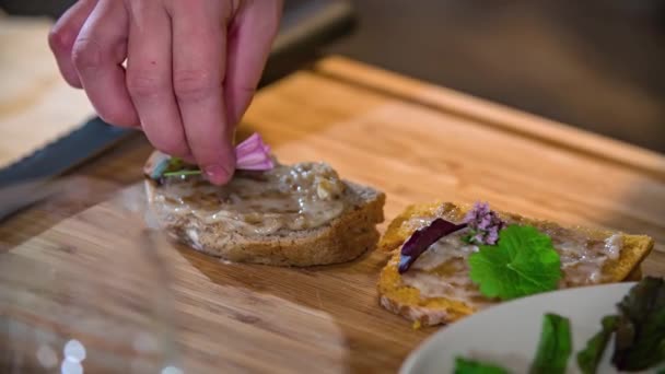 Lento Movimiento Chef Decorando Pedazo Pan Untado Con Flores Comestibles — Vídeos de Stock