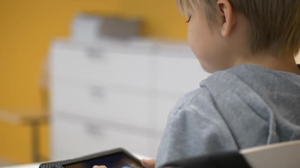 Zadní Pohled Mladého Školáka Hrát Hru Tabletu Zblízka — Stock video