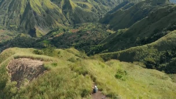 山の景色を見るために歩いて男の子の空中ドローンショット — ストック動画