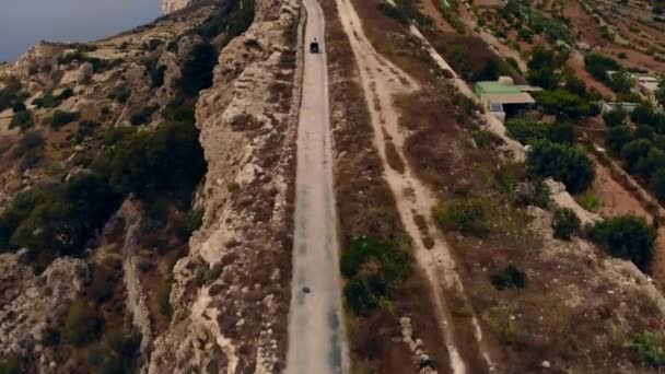 崖の端に近い未舗装道路上の空中追跡クワッド シースケープバックアップ マルタのゴゾ — ストック動画