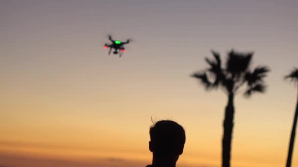 無人機がシルエットの男の上を飛ぶ — ストック動画