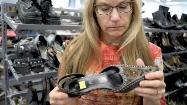 Pretty Blond Woman Inspects Pair Middle Eastern Shoes Carefully — Stok video