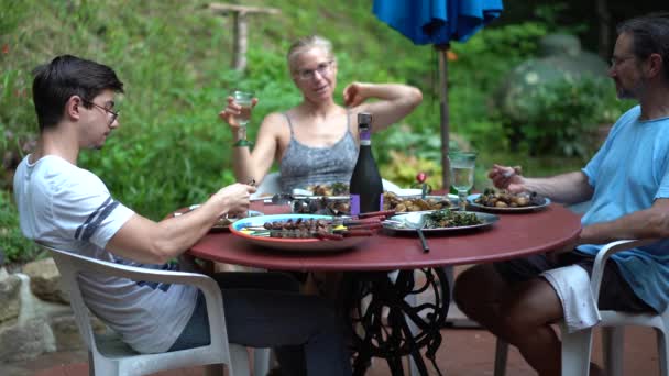 Familie Zit Rond Een Tafel Eten Een Terras Een Tuin — Stockvideo