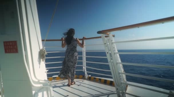 若いです女の子は美しい深い青色の海を見下ろすクルーズ船の前に立って — ストック動画