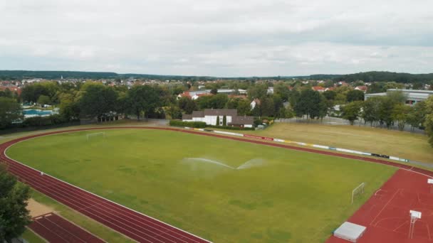 遠くにトラック サッカー場 プールの空中ドローン右パンニングショット — ストック動画