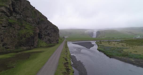 アイスランドの川や崖が道や川を飛んでいるスコガフォスの滝の空中撮影 — ストック動画