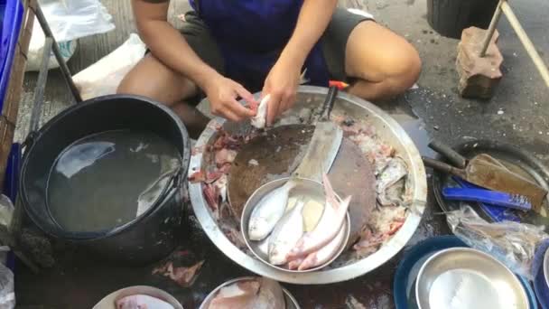 Man vágja friss hal a reggeli utcai piacon élelmiszer Thaiföldön az ügyfél, közelről kézzel vágás hal.