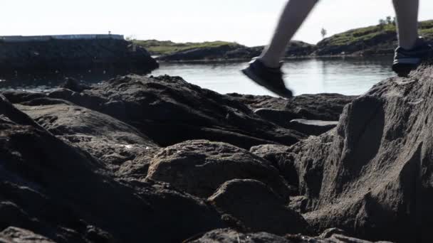 在海洋附近的岩石上跳跃 — 图库视频影像